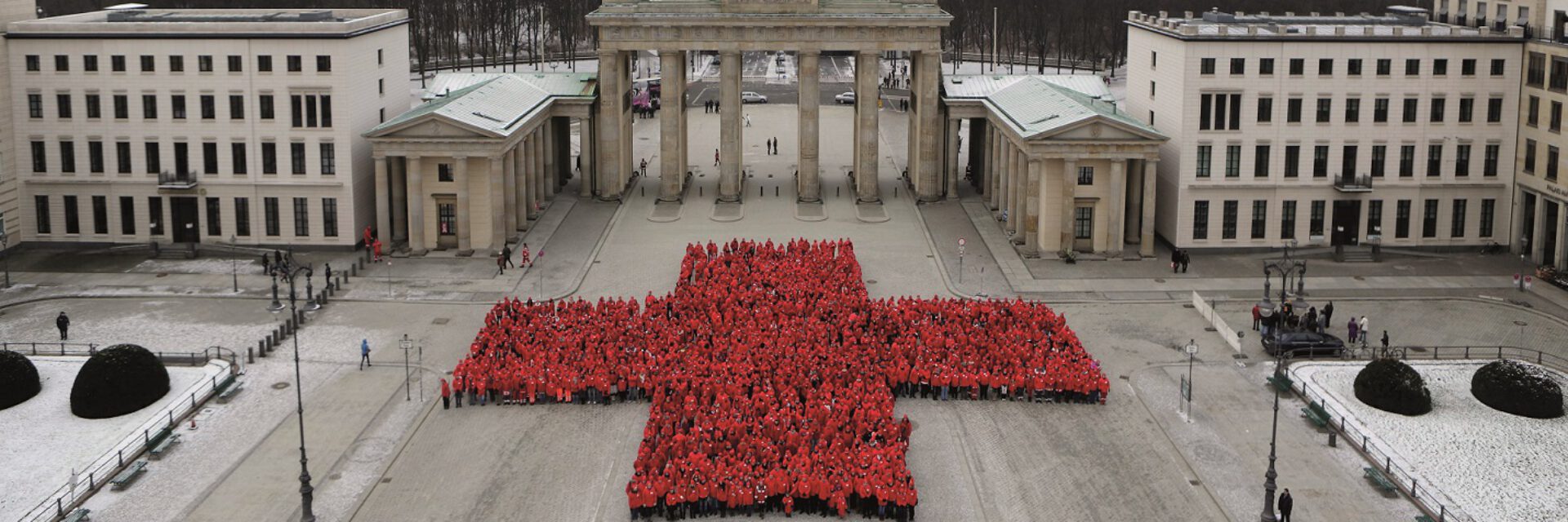 Menschenansammlung am Brandenburger Tor, welche ein rotes Kreuz abbilden