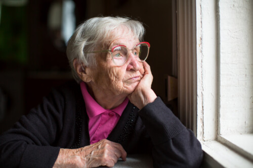 iStock-609707574-500x333 Elderly woman in glasses thoughtfully looking out the window.