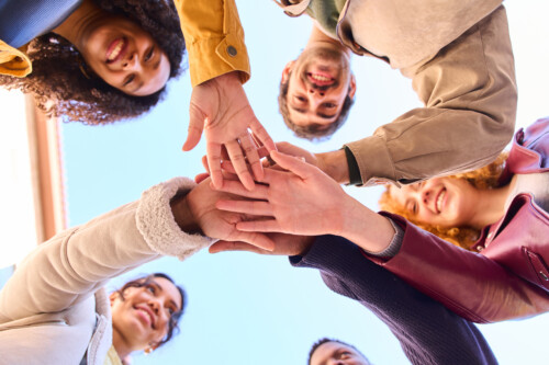 iStock-2213164038-1-500x333 Group of students joining hands in teamwork and collaboration